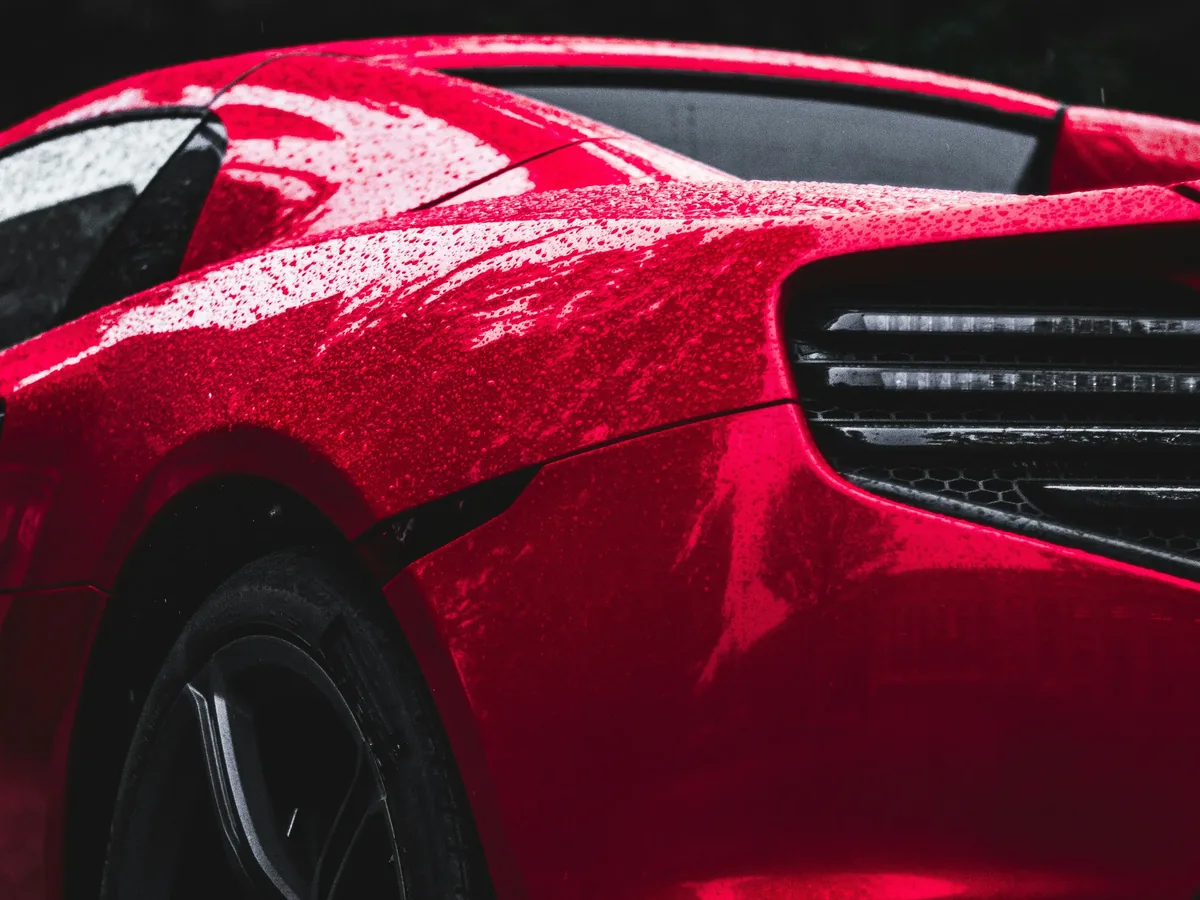 Water beading across a red rear quarter panel